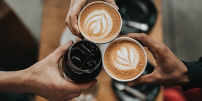 Professional barista pouring latte art, steaming coffee cup, espresso machine background, coffee beans scattered, warm tones, high quality photography
